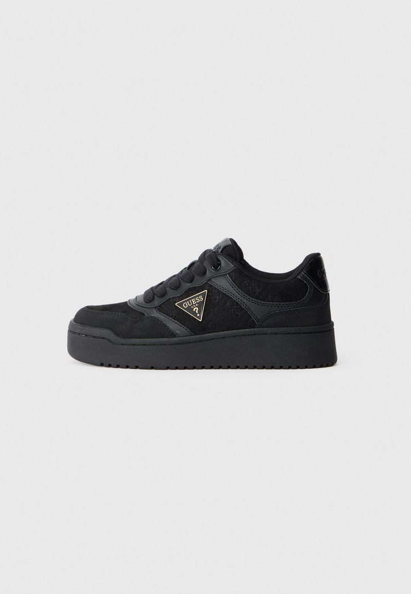 Baskets noires en suède et matériaux synthétiques, présentant un design texturé, un col rembourré et un accent de logo doré sur le côté.
