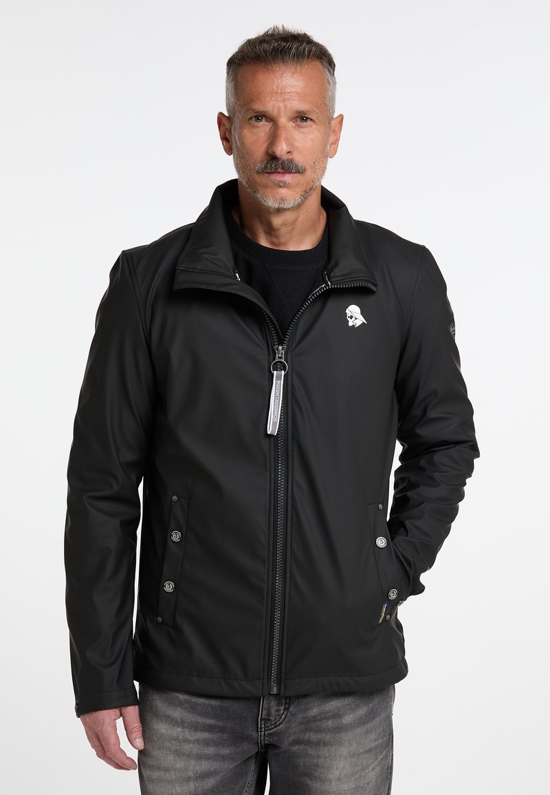 Jachetă neagră din material softshell, cu guler în stil stand, fermoar în față și două buzunare laterale. Prezintă detalii cu logo pe piept și accente din metal argintiu.