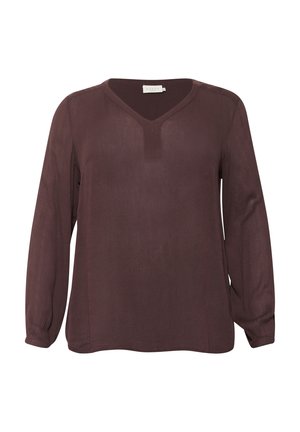 Blouse à manches longues et décolleté en V dans un bordeaux profond. Fabriquée en tissu léger, elle présente un léger éclat et un petit plastron vertical au niveau du décolleté.