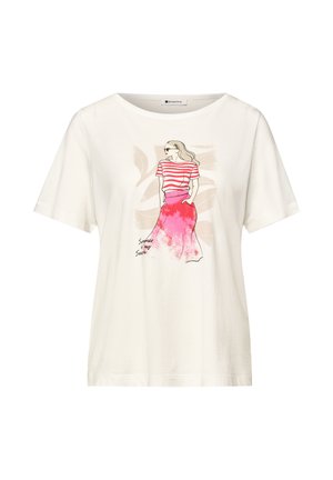 T-shirt blanc à manches courtes avec illustration d'une femme portant un haut rayé rouge et une jupe rose, les mains dans les poches.
