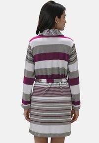 Bata de baño a rayas en colores morado, gris y blanco, con cintura con cinturón y mangas largas, fabricada en una suave tela texturizada.