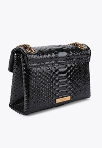 Borsa nera in pelle sintetica a forma di serpente con finitura lucida, dettagli in catena dorata e forma rettangolare, caratterizzata da squame testurizzate e una piastrina con logo.