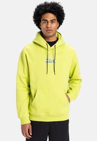 Lime green hoodie with a front pocket and drawstrings. Features blue graphic text in the center. Made of soft fabric, relaxed fit.