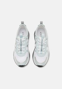 Scarpe sportive blu chiaro e bianche con una tomaia testurizzata, dotate di dettagli argentati, suola nera e lacci bianchi. Logo del marchio visibile.