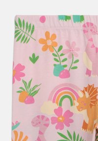 Light pink leggings featuring a vibrant pattern of dinosaurs, flowers, and greenery, with a colorful rainbow and playful accents.