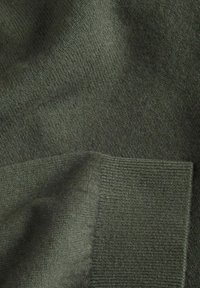 Strickpullover in Dunkelgrün, mit weicher Textur und gerippten Bündchen, insgesamt mit glatter Oberfläche.