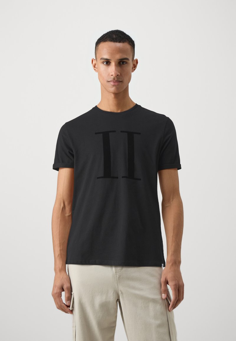 T-shirt en coton noir avec un graphique audacieux "II" dans une texture douce. Manches courtes et col rond.