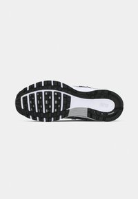 Sole di scarpa Nike in bianco e nero con motivi di battistrada rettangolari e il nome del marchio impresso vicino al tallone.