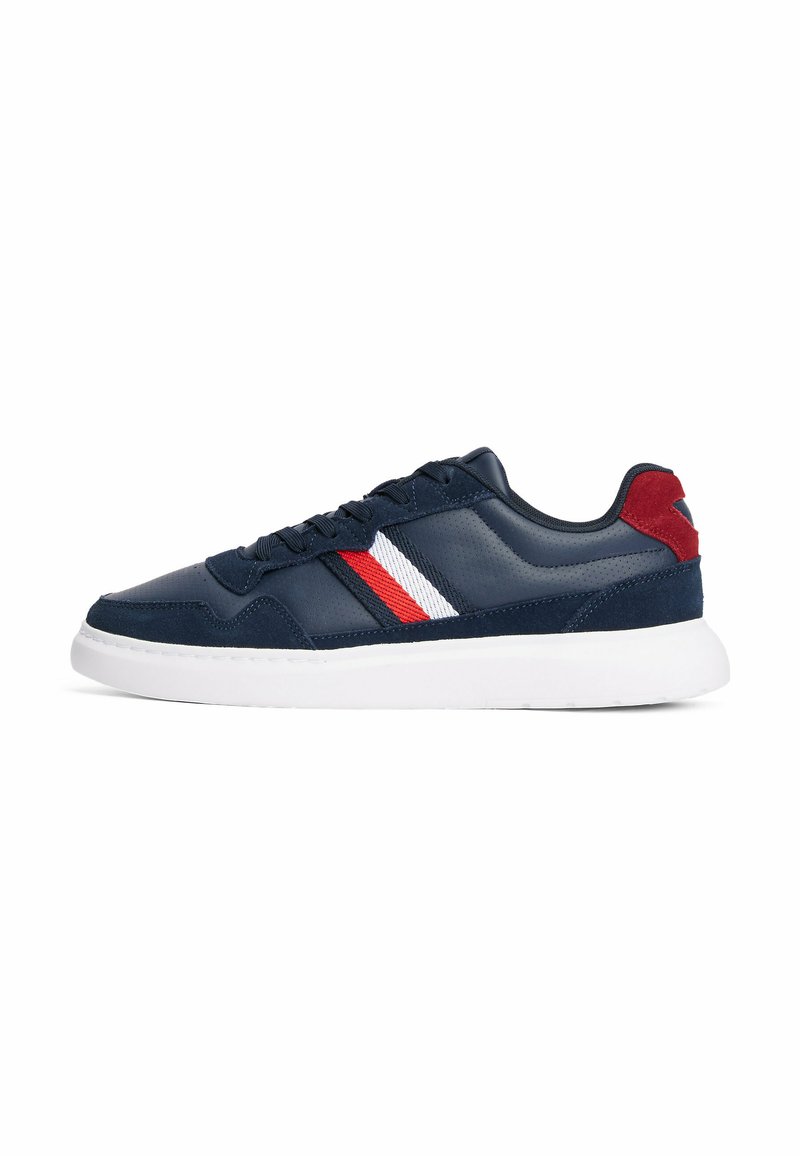 Sneaker navy con tomaia in pelle liscia, suola bianca e accenti a strisce rosse e bianche sui lati. Presenta un tallone in suede texturizzato.