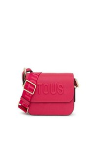 Bolso bandolera de cuero rosa con tapa magnética, logo "TOUS" en relieve y correa ajustable con patrón para un uso versátil. Acentos de hardware en tono dorado.