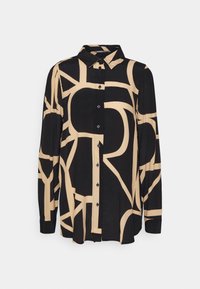 Chemise noire à manches longues boutonnée avec motifs géométriques abstraits beige et col pointu.
