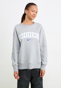 Grijze sweatshirt gemaakt van een katoenmix met brede boorden en een geribbelde zoom. Heeft gedurfde witte tekst "GODDESS" en een blauwe Nike swoosh logo.