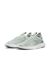 Light green athletic shoes with a textured knit upper, white rubber sole, and minimal accents, featuring a slip-on design and elastic laces.