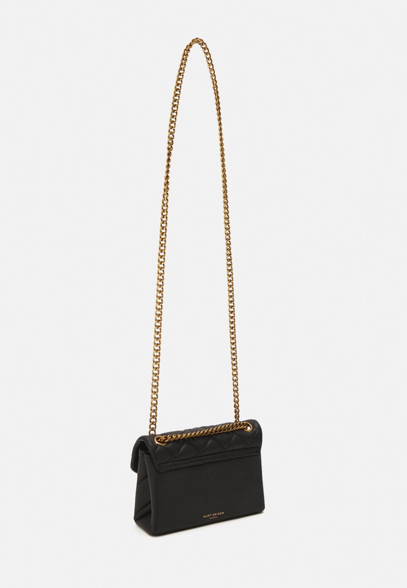 Borsa a tracolla in pelle trapuntata nera con catena dorata, dotata di chiusura a pattina e design semplice. Forma compatta con linee pulite.