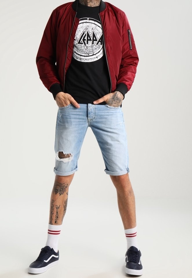 Burgundy bomber jacket with ribbed cuffs, black graphic t-shirt, light blue ripped denim shorts, and navy sneakers with white soles.