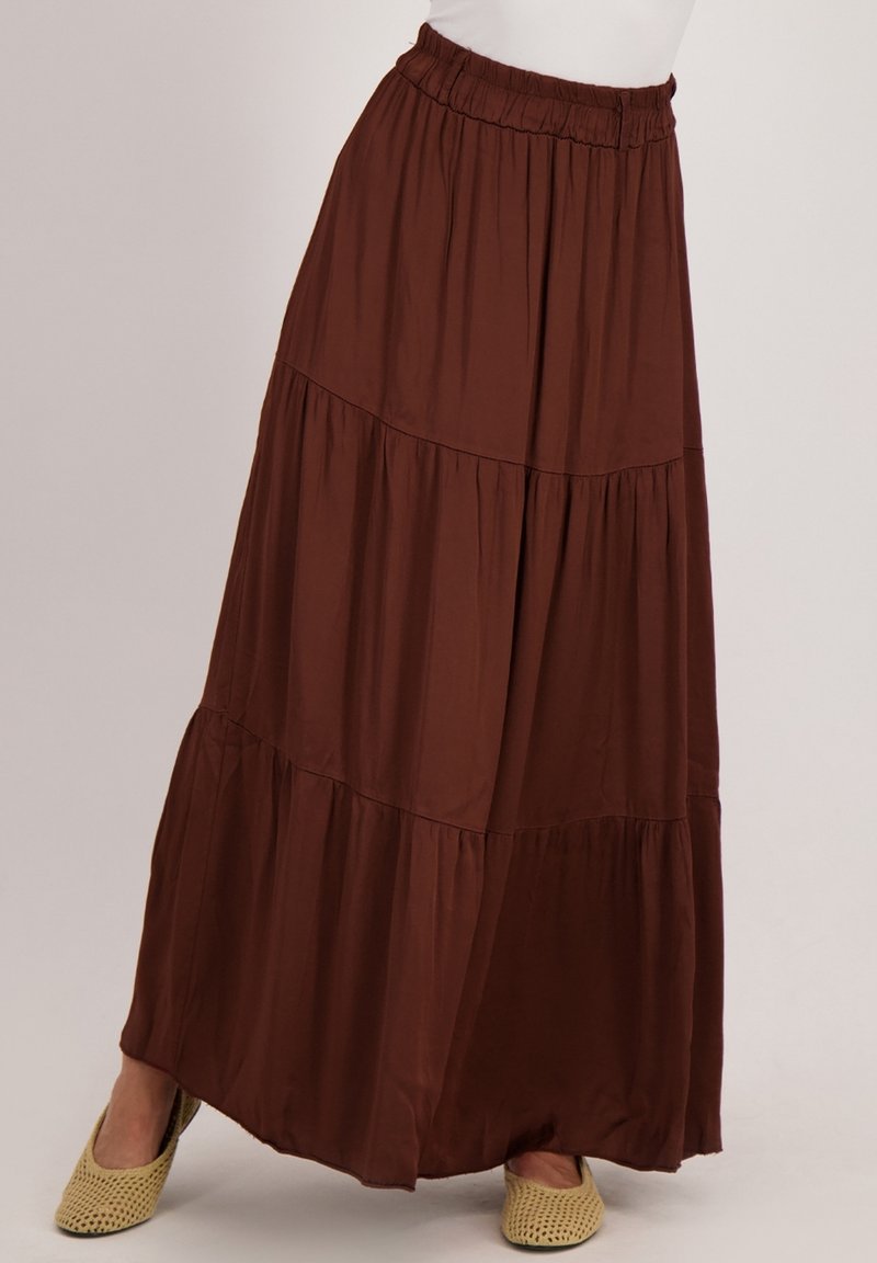 Bruine tiered maxi-rok van lichtgewicht stof met een elastische tailleband en een vloeiende zoom. Beschikt over een zachte textuur en een subtiele glans.