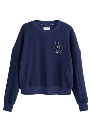 Navy blue textured long-sleeve cropped sweatshirt with a small gold embroidered "b" on the left chest.