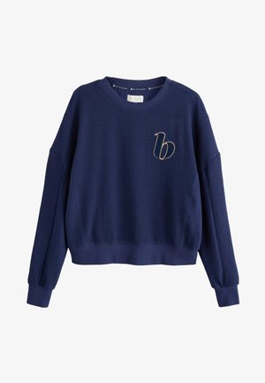 Sudadera corta azul marino texturizada con manga larga y una pequeña "b" dorada bordada en el pecho izquierdo.