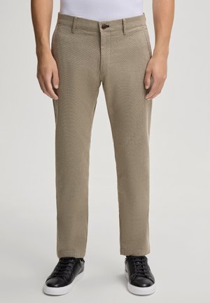 Beige maßgeschneiderte Hose aus strukturiertem Stoff, schlanker Schnitt und mit Knopfverschluss. Tragen Sie sie mit schwarzen Sneakers für einen Kontrast.