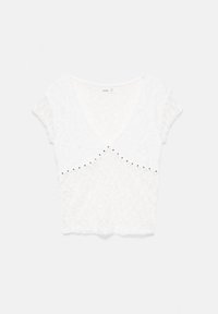 Blouse blanche texturée à manches courtes avec un col en V et de petits clous métalliques disposés en ligne courbe sous la poitrine.