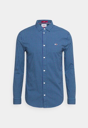 Chemise à manches longues à carreaux bleus et blancs, boutonnée, avec col et petit logo Tommy Hilfiger sur la poitrine gauche.