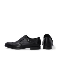 Černé kožené boty s kulatou špičkou, dvojitým přezkovým zdobením, brogue detaily a plochou gumovou podrážkou. Jednoduchý a elegantní design.