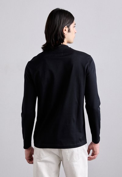 Melns garās piedurknes krekls no mīksta auduma, ar vienkāršu dizainu un noapaļotu kakla izgriezumu, skatīts no aizmugures.