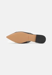 Črne usnjene čevlje s koničastim nosom in nude gumo podplatom. Gladka tekstura, eleganten dizajn in nizka peta za stabilnost. Diskretno embosirano logo.