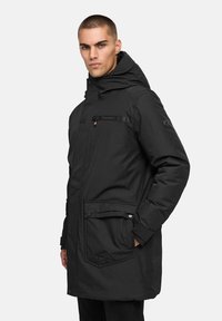 Melnas siltumizolētais jakas ar kapuci, priekšējām kabatām, pogu un rāvējslēdzēja aizdari, smalks zīmola elements un eleganta, piegriezta forma.