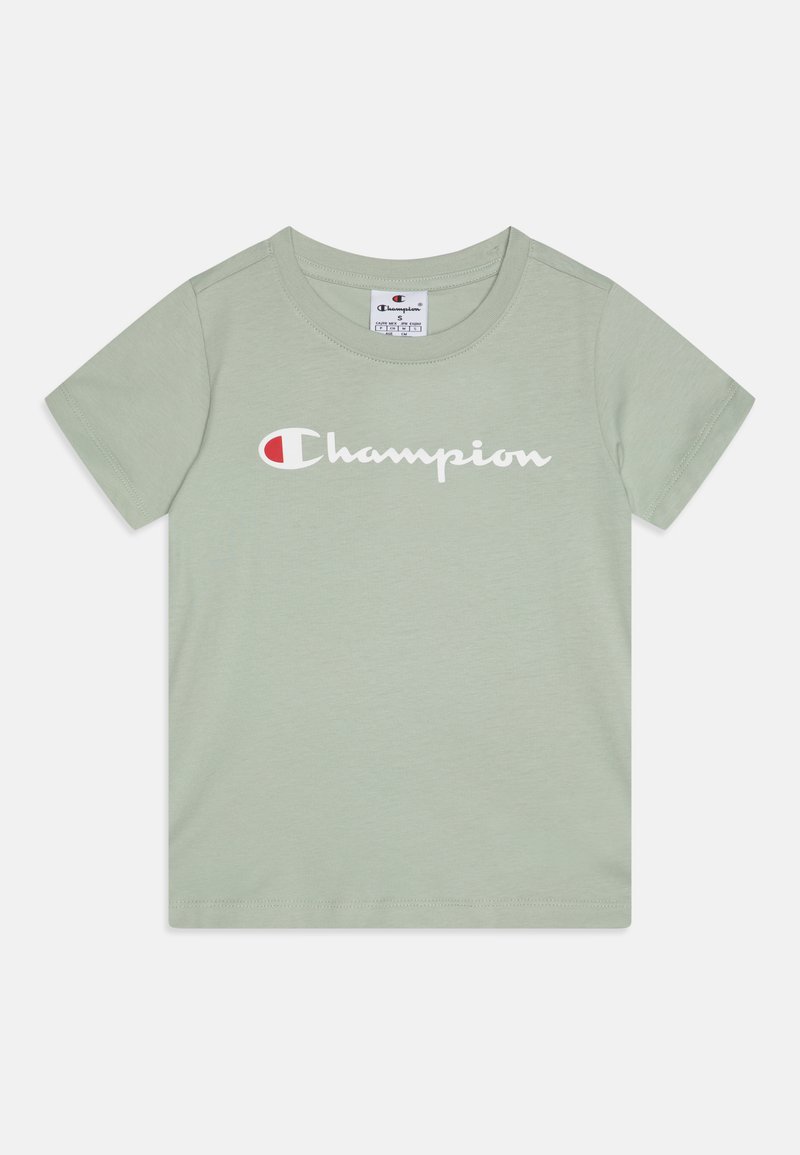 Gaiši zaļš īsu piedurkņu t-krekls, kas izgatavots no mīksta kokvilnas, ar baltu "Champion" logo centrā uz krūšdaļas. Apaļš izgriezums un standarta piegriezums.