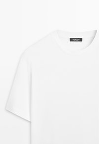 Schlichtes weißes T-Shirt mit kurzen Ärmeln und rundem Ausschnitt, mit einem sichtbaren schwarzen Etikett am Kragen, auf dem "Massimo Dutti" steht.