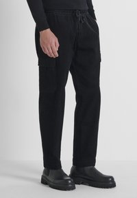 Schwarze Corduroy-Cargo-Hosen mit elastischem Bund, Seitentaschen und geradem Schnitt. Strukturierter Stoff mit weichem Griff.