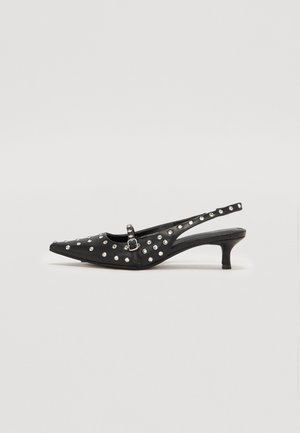 Black slingback shoes with a pointed toe, decorated with silver studs, featuring a low heel and a buckle strap detail.