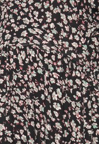 Vestido floral preto com um padrão denso de flores verdes e brancas com detalhes em vermelho, design de saia plissada, feito de tecido suave.