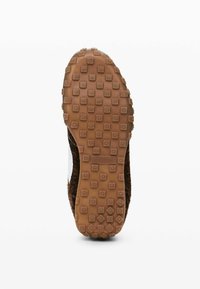 Talpa de sneaker din cauciuc maro, cu o suprafață texturată și modelată. Prezintă mici gripuri pătrate și circulare pentru tracțiune. Accente laterale albe clare.