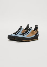 Pantofi bleu deschis și maro cu accente negre, superior din suede texturat și plasă, talpă din cauciuc și taburi în spate pentru o îmbrăcare ușoară.