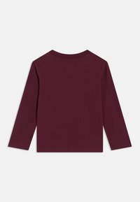 Μπλούζα μακρυμάνικη, μονοχρωμη σε σκούρο μωβ χρώμα με στρογγυλή λαιμόκοψη, απλωμένη επίπεδα σε λευκό φόντο.