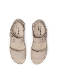 Beige sandals with a textured upper, adjustable ankle strap, and cushioned insole. Features a smooth finish and open-toe design. Size 39.