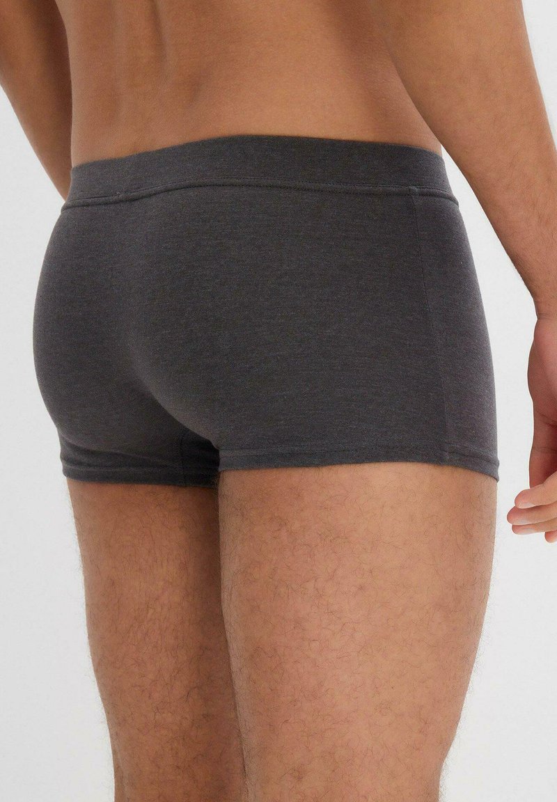 Boxer briefs da uomo grigio scuro realizzati in tessuto morbido, con un cinturino liscio e una vestibilità aderente, progettati per il comfort e la mobilità.