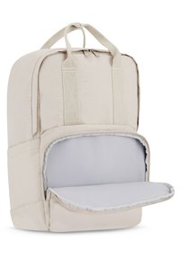 Beige ryggsäck i tyg med två handtag på toppen, dragkedjestängning och ett vadderat grått inre med en platt hylla för organiserad förvaring.