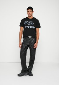 Melnā T-krekls ar zilā grafiti stilā 