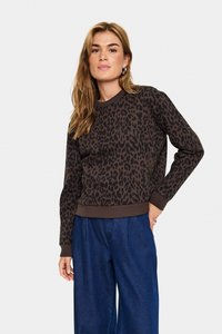 Sweatshirt à imprimé léopard brun avec un col rond et des manches longues. Poignets et ourlet côtelés ; porté avec un pantalon en denim bleu ample.