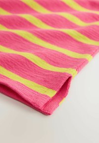 Gros plan sur un tissu plié avec des rayures horizontales alternées roses et jaunes sur un fond clair.