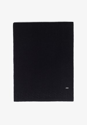 Czarny dziergany koc z teksturowanym wzorem wzdłuż dolnej krawędzi oraz małą metalową metką z logo w jednym rogu. Miękki materiał.