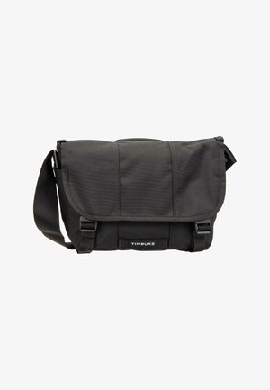 Schwarze Timbuk2-Umhängetasche mit verstellbarem Schultergurt, Klappverschluss und zwei vorderen Schnallenverschlüssen. Die Tasche wirkt neu und unbenutzt.