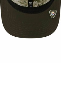 Grüne Kappe mit geradem Schild, ausgestattet mit einem Camouflage-Innenfutter. Enthält ein metallisches Logo-Element an der Seite. Flaches Schild-Design mit Stichdetails.