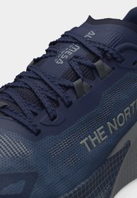 Σκούρο μπλε αθλητικό παπούτσι της The North Face με υφασμένο δίχτυ, πλεκτά κορδόνια και το λογότυπο "ALTMESA" στη γλώσσα του παπουτσιού.