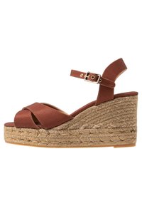 Hnědé platformové sandály na klínu z textilie se zkříženými pásky, nastavitelným páskem kolem kotníku a střední částí obalenou jutou. Hladká podešev.