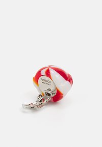Fiorucci kulcstartó, amely egy kerek, több színű gyanta bájjal rendelkezik, piros és fehér örvényekkel, ezüst színű fémből készült klipszel a könnyű rögzítés érdekében.