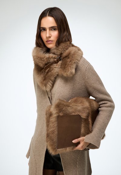 Beżowy dziergany kardigan z brązowym kołnierzem z futra oraz dopasowanym kopertówką z futrzanymi akcentami, charakteryzujący się gładkimi teksturami i ciepłymi tonami.